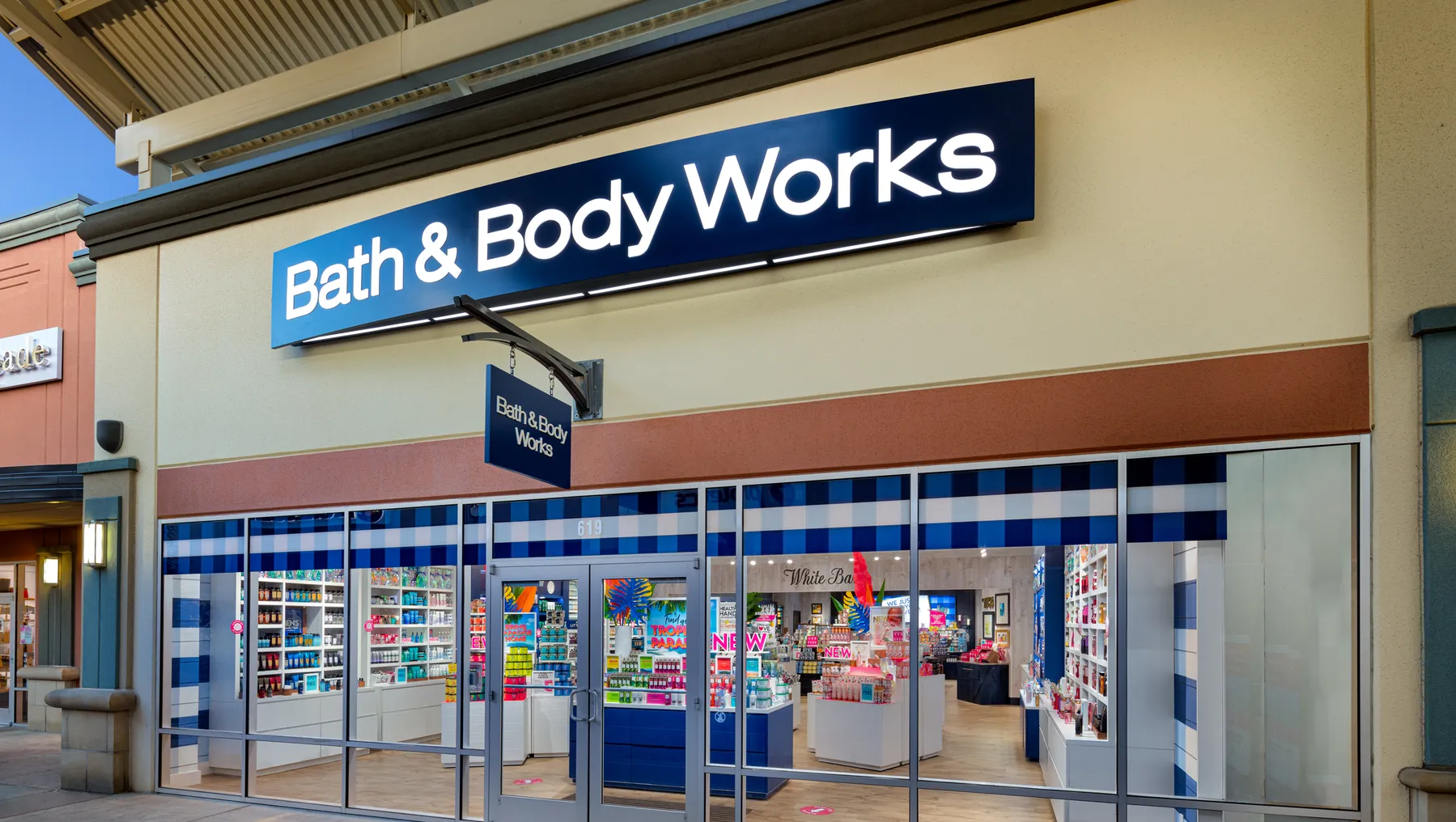 The exterior of a store with a banner that reads "Bath & Body Works."