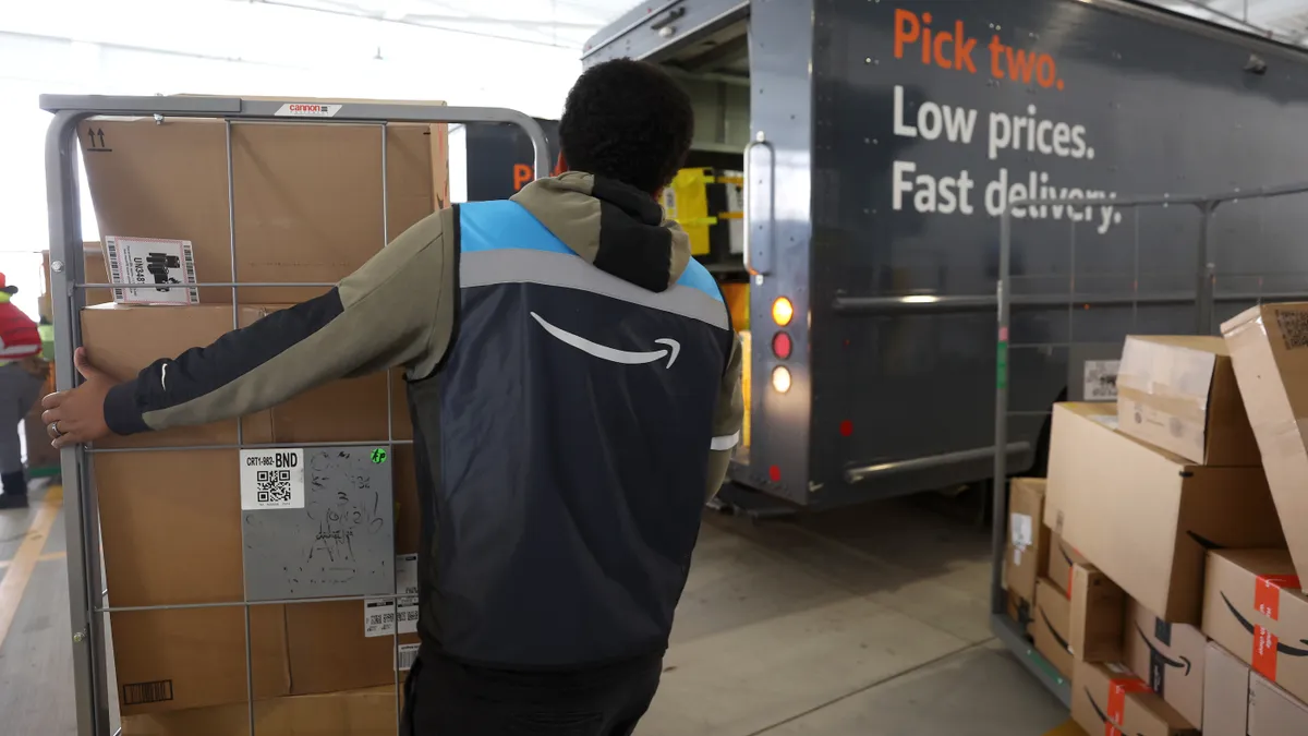 An Amazon driver loads packages into a delivery van at an Amazon delivery station on November 28, 2022 in Alpharetta, Georgia.