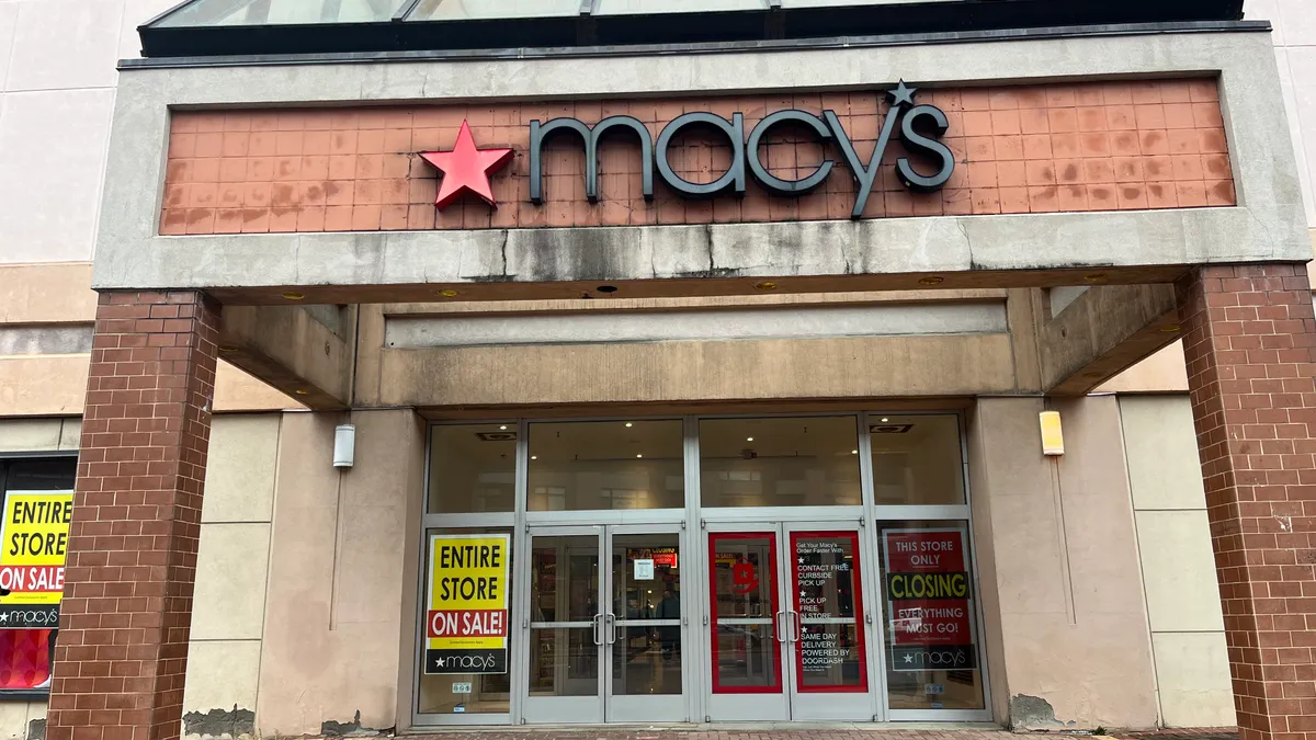 A Macy's storefront displaying sale signs.