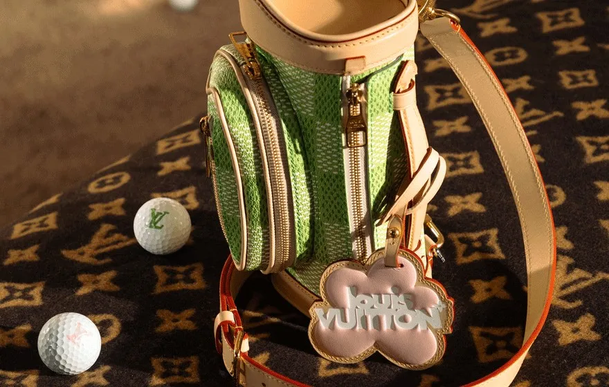 A mini golf bag in green sits next to two golf balls.