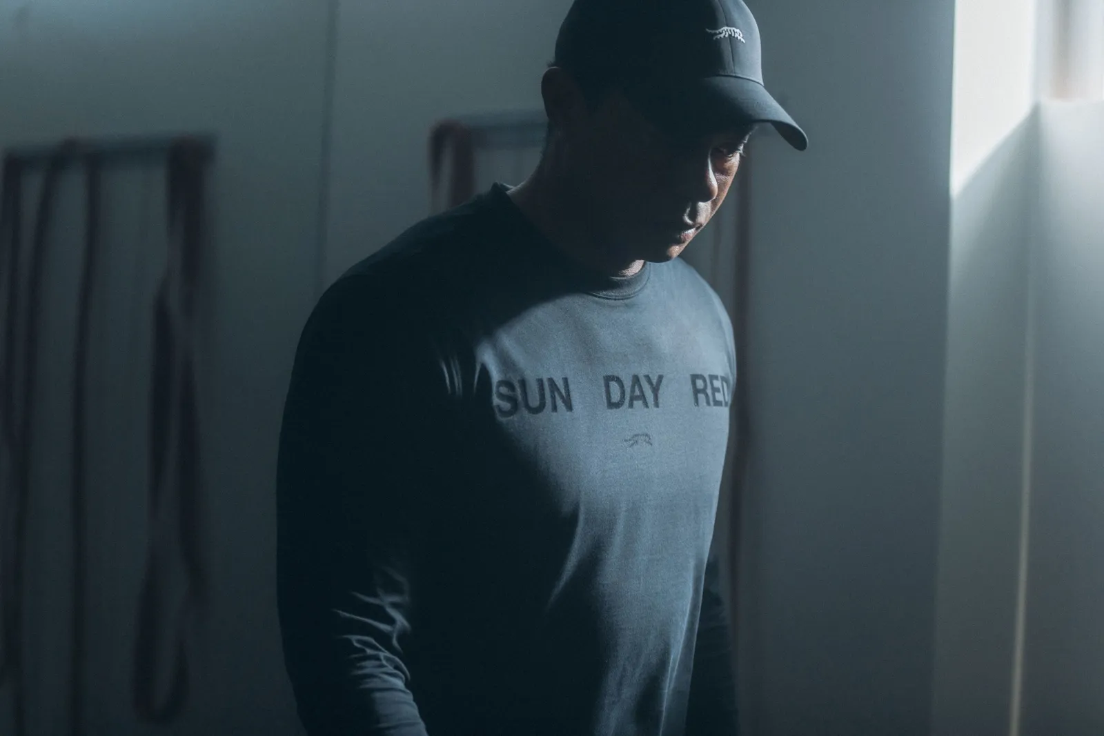 Tiger Woods in a dark blue long sleeves t-shirt with the words Sun Day Red on the front.